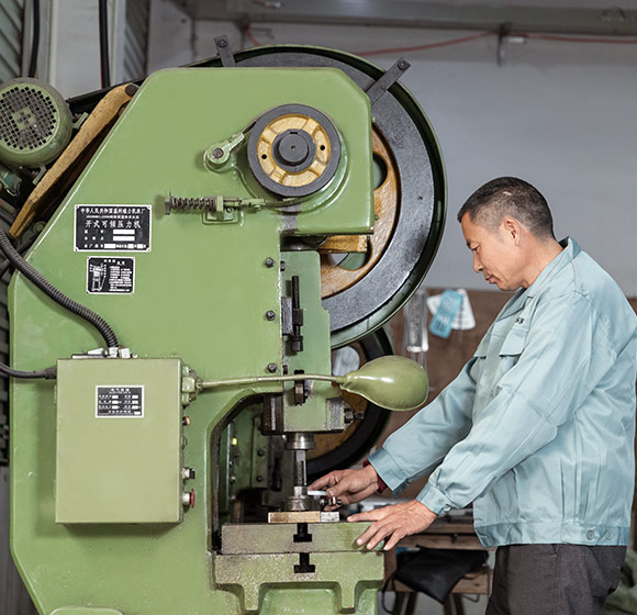 A worker is operating a machine in the factory